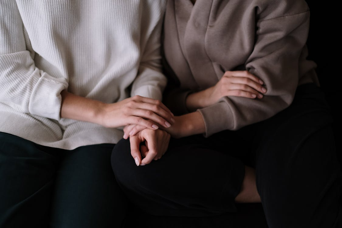 Two people sitting close together while offering quiet emotional support